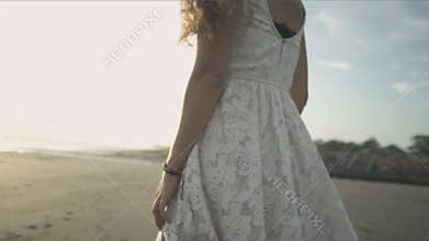 Carefree woman dancing in the sunset on the beach