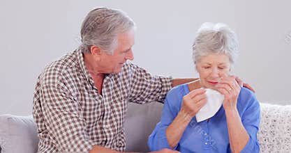 Kind elderly husband comforting his wife