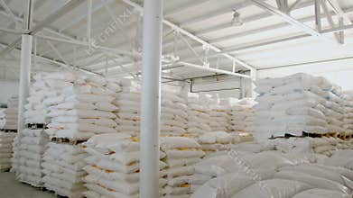 Bags with flour in warehouse of flour factory. Flour stock. Mill warehouse