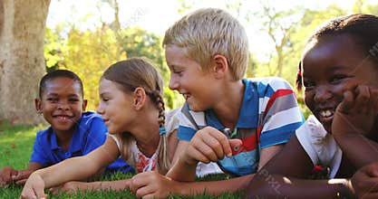 Group of smiling kids lying on grass