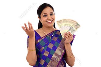 Happy young traditional woman holding Indian currency