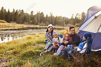 Asian family on a camping trip relax outside their tent