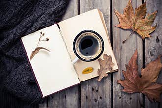 Vintage book, knitted sweater with autumn leaves and coffee mug