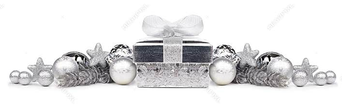 Christmas border of silver ornaments and gift over white