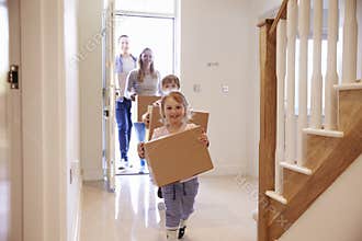 Family Carrying Boxes Into New Home On Moving Day