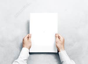 Hand holding white journal with blank cover mockup.