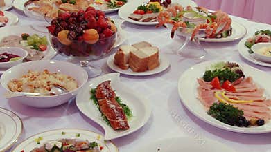 Salads, meat, fish, fruit, strawberries on table.