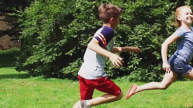 Happy kids running and playing tag game outdoors