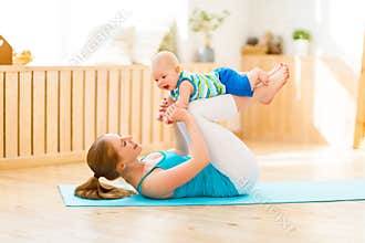 Sports mother is engaged in fitness and yoga with baby at home