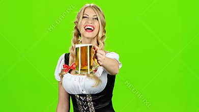 Girl in bavarian costume is luring someone for a glass of beer. Green screen