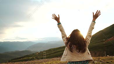 Happy celebrating winning success woman at sunset or sunrise standing elated with arms raised up above her head in