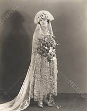 Bride wearing ruffled wedding gown and flowered headdress
