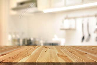 Wood table top (as kitchen island) on blur kitchen interior back