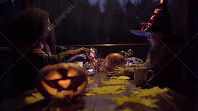 Two teen girls sharing candys after trick or treat on Halloween night