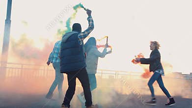 Excited people with colored smoke grenades