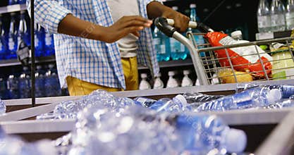 Man buying bottle of water at grocery section