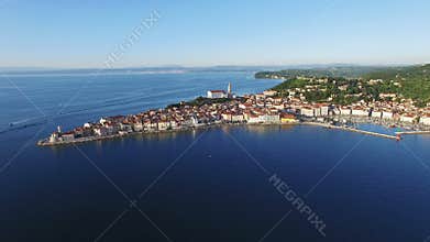 Flight over old city Piran in Slovenia, aerial panoramic view with St. George's Parish Church, fortress and the sea.