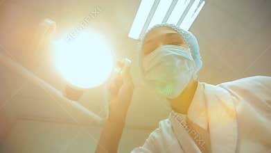 Dentist holding dental lamp and tools