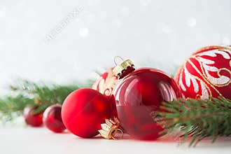 Red ornaments and xmas tree on glitter holiday background. Merry christmas card.