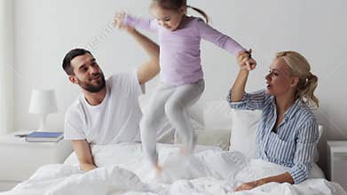Happy family having fun in bed at home