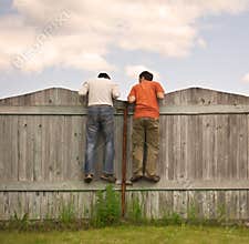 Two boys on the fence looking for smth