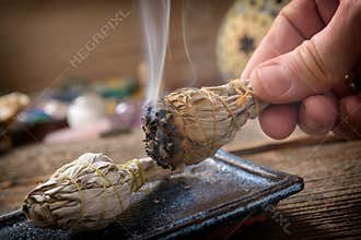 Man burning white sage incense