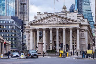 London, England - The Royal Exchange building with moving traditional black london taxi