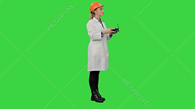 Female engineer correct parts of an object using remote controller on a Green Screen, Chroma Key.