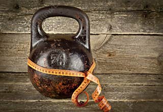 Vintage kettlebell on a wooden background with tape-measure