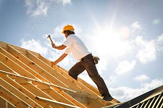 Roofer carpenter working on roof on construction site