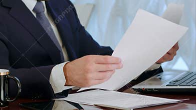 Businessman signing documents with a cup of coffee on the table