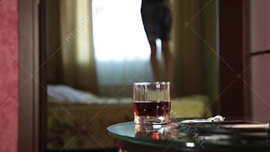 Young drunk arab girl funny jumping on a bed. close-up glass of brandy