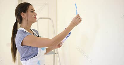 Young decorator deciding on a color of paint