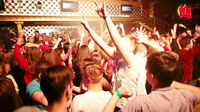 Night dance party with a group of drunken young people in the club to the music and the light flashes