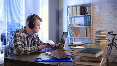 Student learning online with headphones and laptop
