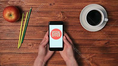 Female hands showing mobile phone with sale offers