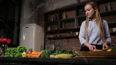 Young woman cooking healthy smoothie in kitchen