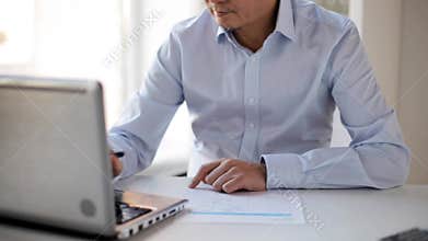 Businessman with laptop and papers at office