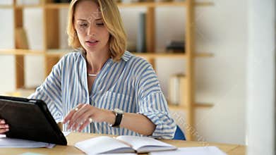 Cheerful young woman making notes while studying at home