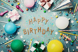 Happy birthday background or greeting card. Colorful festive decoration on turquoise vintage table top view. Flat lay style.