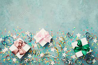 Gift or present box decorated colorful confetti, star and streamer on blue vintage table top view. Flat lay style. Birthday.