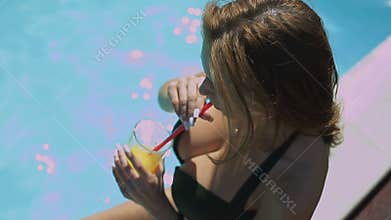 Bikini Girl relaxing at the edge of swimming pool