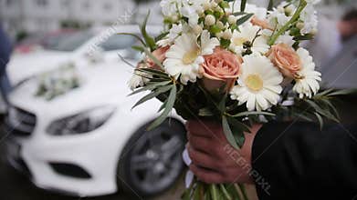 Wedding bouquet in front of luxury car