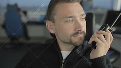 Portrait of man with portable radio in control tower