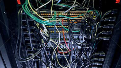 Intertwining cables inside a large switch cabinet.