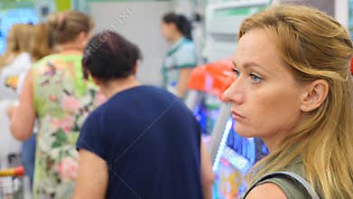 The queue of people standing at the checkout in the supermarket. 4k, slow motion