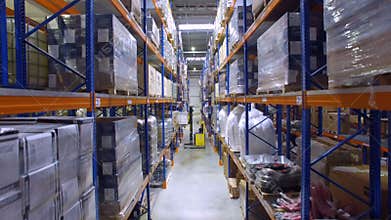 Forklift in a warehouse. Modern forklift unloading racks, shelves in storehouse. Aerial.