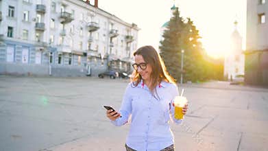 4 in 1 video. Man and woman talking on smartphone and drinking juice walking down the street, slow motion