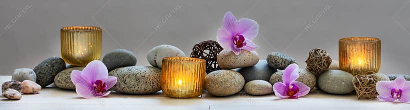 Concept of wellbeing with pebbles, orchids and candles, panoramic