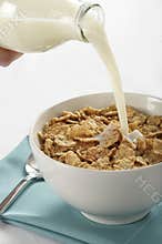 Milk pouring into cereal bowl